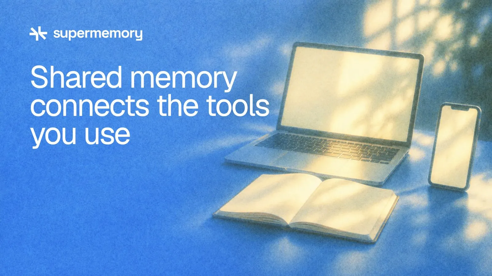 Supermemory header reading "Shared memory connects the tools you use" — A laptop, phone and notebook share one continuous pool of warm light